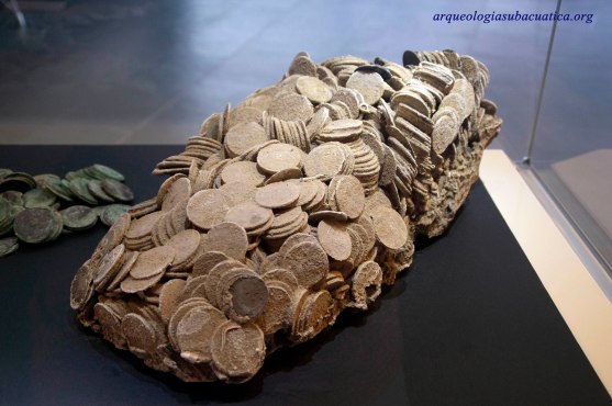 Conjunto de monedas extraidas del naufragio de la fragata Mercedes que conserva la forma de la caja que las contenía. ARQVA.